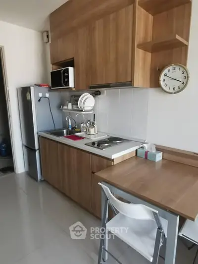 Modern compact kitchen with wooden cabinets and sleek appliances