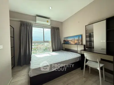 Modern bedroom with city view, featuring sleek furniture and ample natural light.