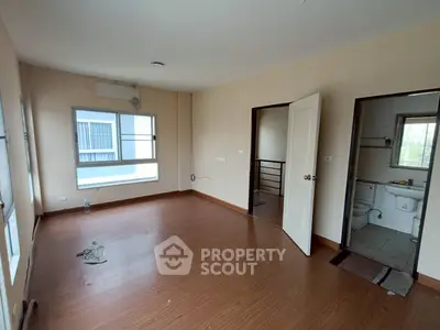 Spacious empty room with wooden flooring and natural light
