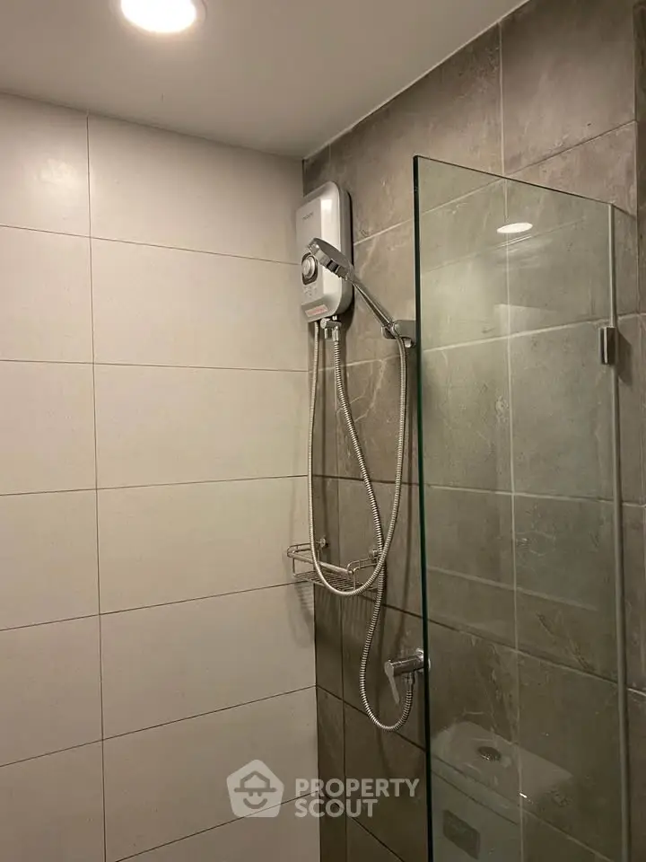 Modern bathroom with sleek shower and glass partition in contemporary home.