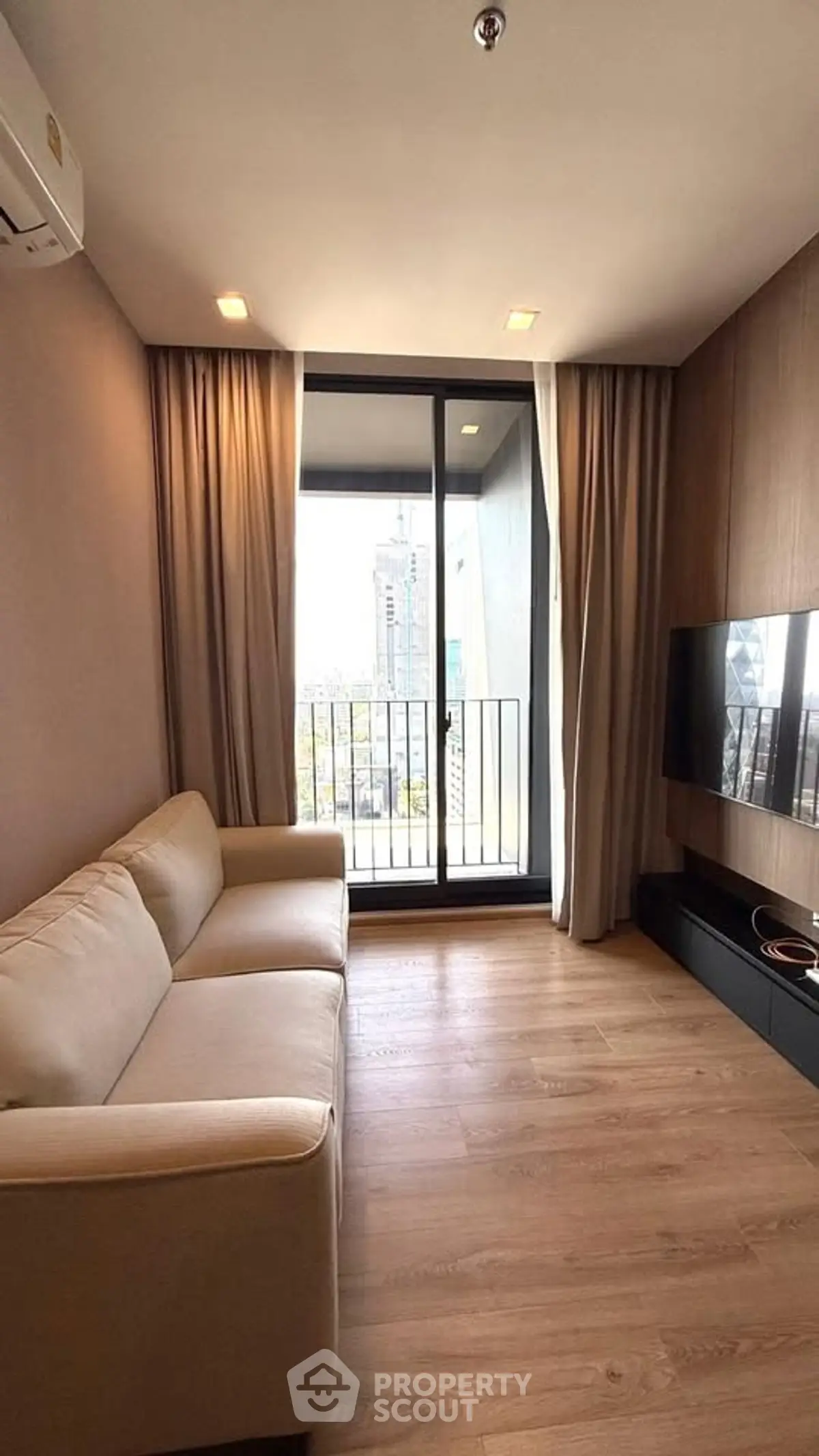 Modern living room with cozy sofa and city view balcony, perfect for urban living.