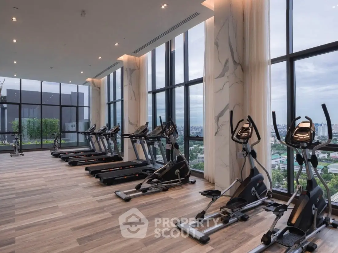 Luxury high-rise gym with panoramic city views and modern equipment.