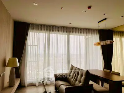 Spacious living room with modern furniture and large window offering a stunning view.