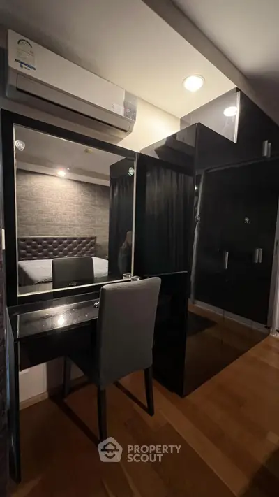 Modern bedroom with sleek black wardrobe and stylish vanity desk