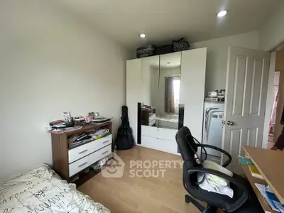 Cozy bedroom with modern wardrobe and workspace, ideal for urban living.