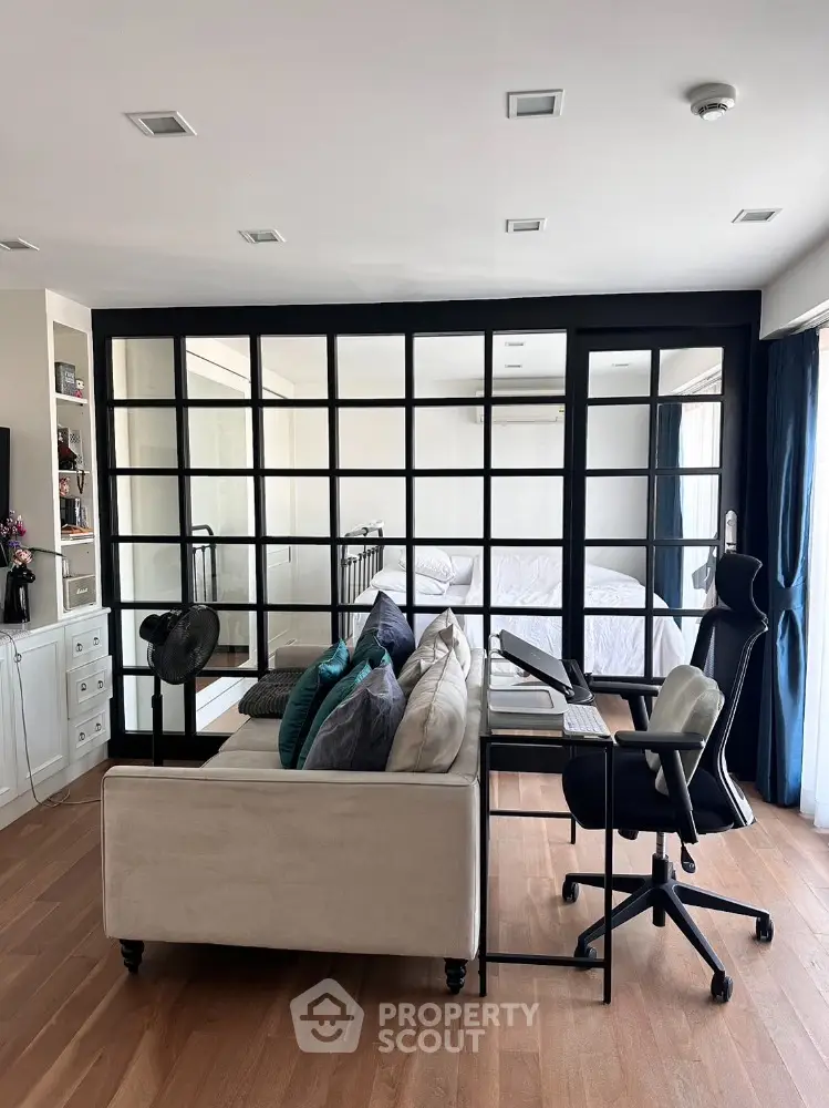 Modern living room with stylish glass partition and cozy workspace