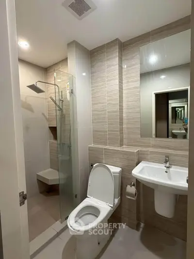 Modern bathroom with sleek design, featuring a glass shower and contemporary fixtures.