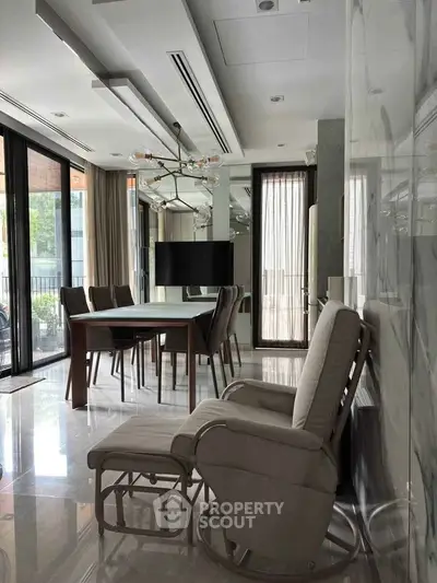 Luxurious modern dining room with elegant furniture and large windows offering natural light.