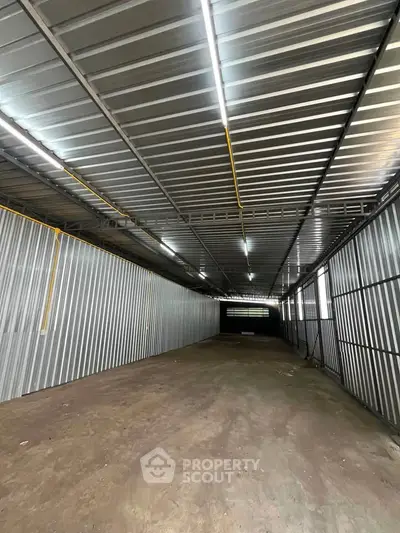 Spacious industrial warehouse with high ceilings and ample lighting, perfect for storage or commercial use.