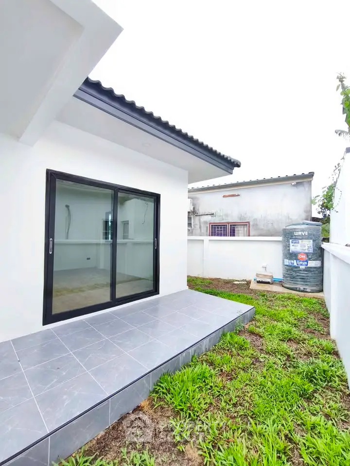Modern single-story home with sliding glass doors and small garden area, perfect for cozy living.
