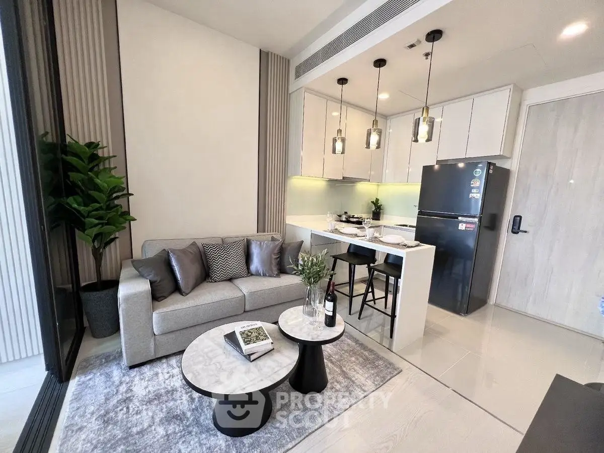 Modern open-plan living room with kitchen, featuring sleek design and contemporary furniture.
