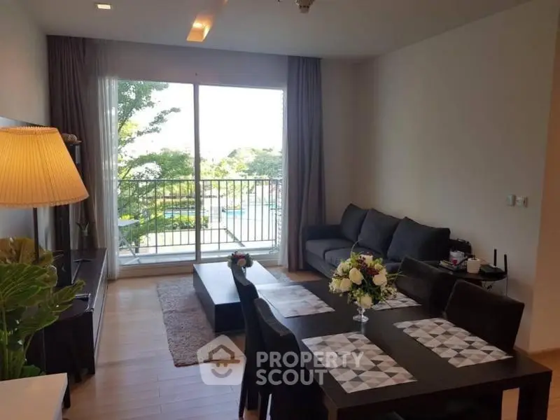 Spacious living room with modern decor and large window overlooking greenery.
