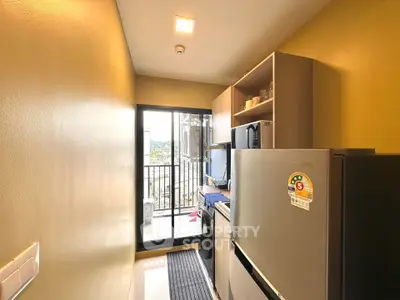 Compact kitchen with modern appliances and balcony view in urban apartment