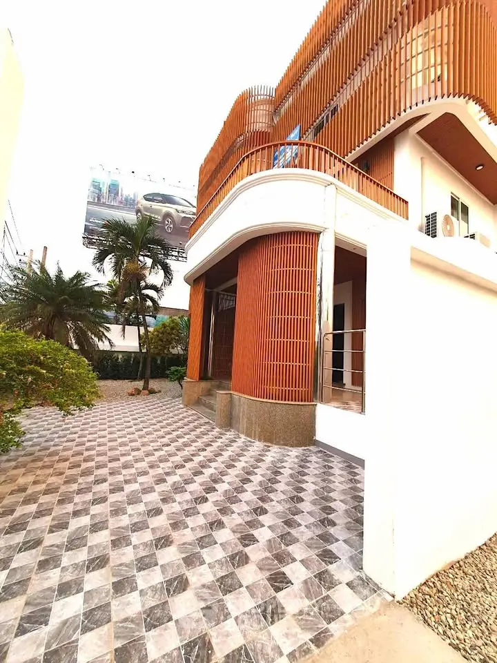 Modern architectural building with unique wooden facade and spacious tiled entrance