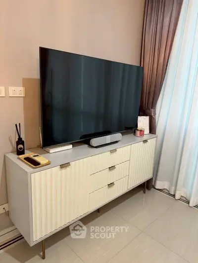 Modern living room with sleek TV stand and large flat-screen TV