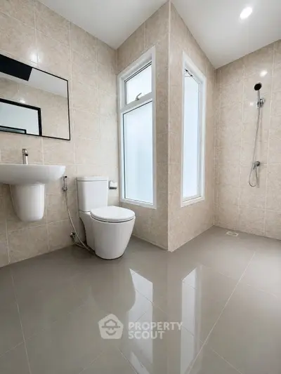 Modern bathroom with sleek fixtures and large window for natural light.