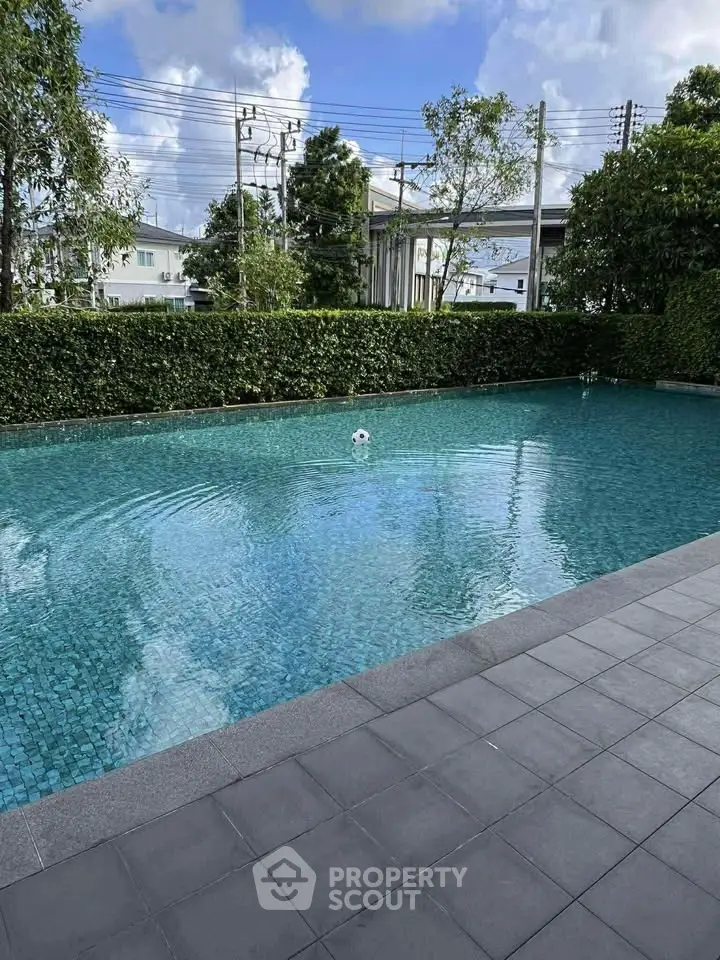 Luxurious outdoor pool with serene surroundings and lush greenery, perfect for relaxation and leisure.