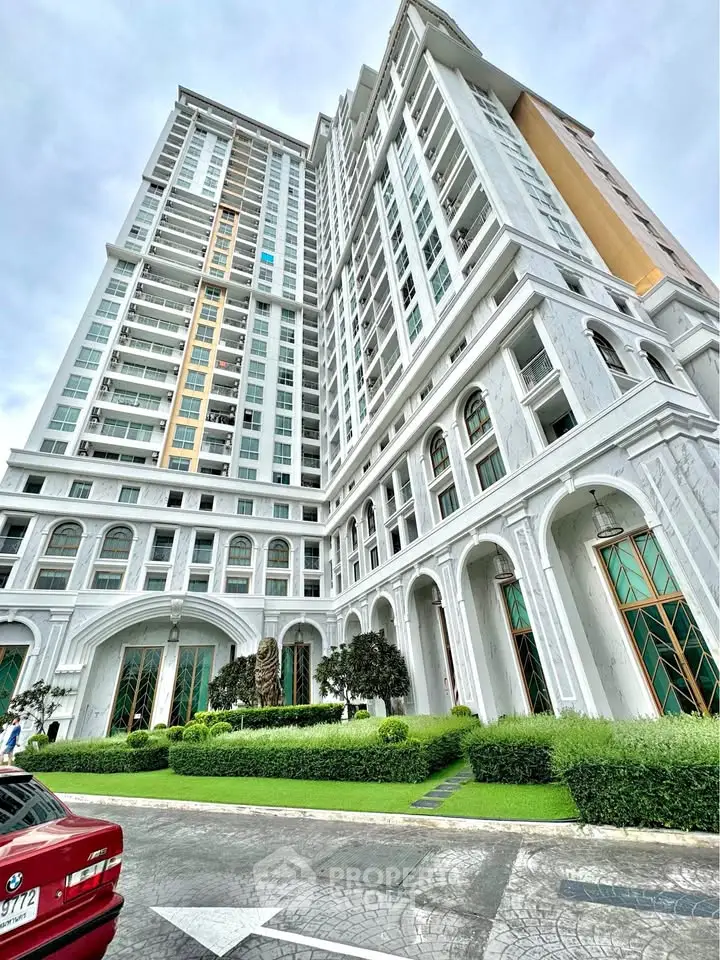 Stunning high-rise building with elegant architecture and lush landscaping, perfect for luxury urban living.