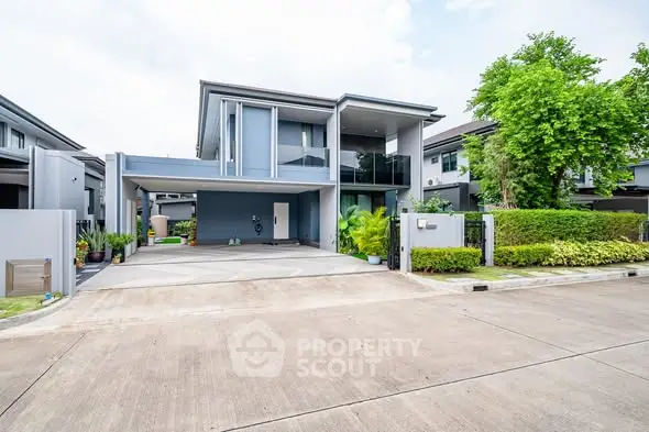 Modern two-story house with spacious driveway and lush greenery