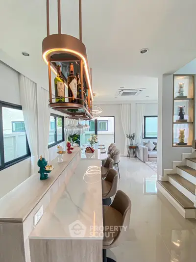 Modern open-plan kitchen with stylish bar counter and elegant lighting