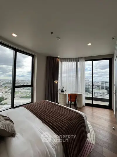 Luxurious bedroom with panoramic city views and elegant decor in a high-rise apartment.