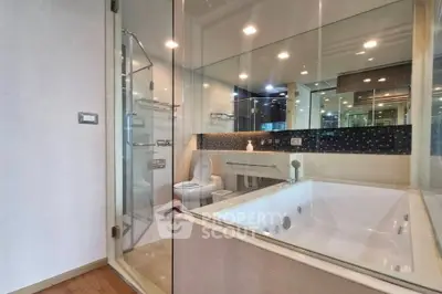 Luxurious modern bathroom with glass walls and large bathtub in elegant apartment.