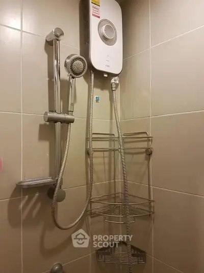 Compact bathroom with modern shower and water heater, ideal for efficient space use.