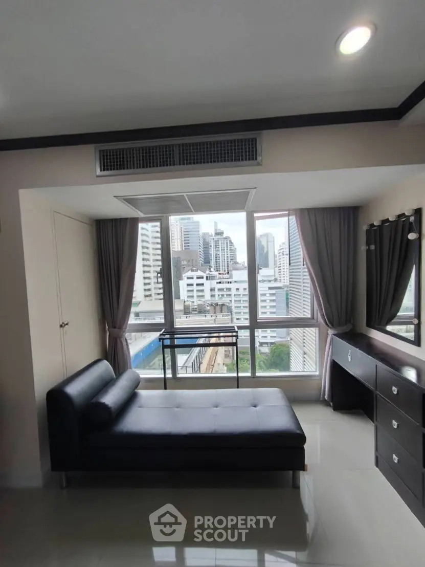 Modern living room with city view, sleek furniture, and large windows in urban apartment.