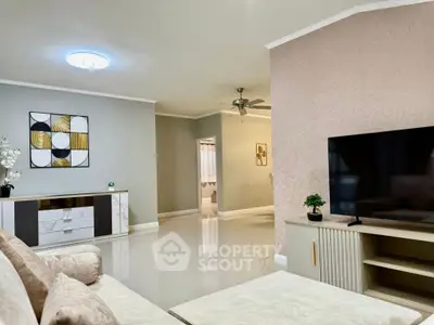 Spacious modern living room with elegant decor and large TV setup