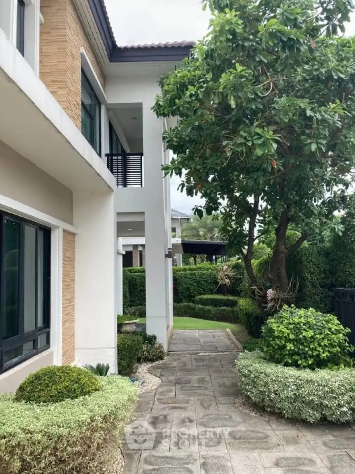 Charming modern house exterior with lush garden and pathway