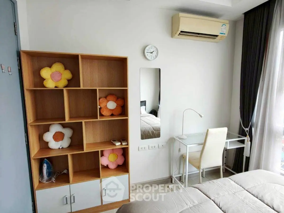 Cozy bedroom with modern decor, featuring a study desk, air conditioning, and stylish shelving.