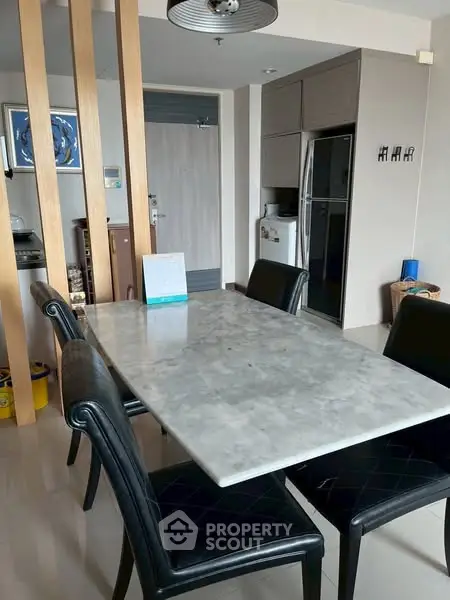 Modern dining area with marble table and leather chairs in stylish apartment.