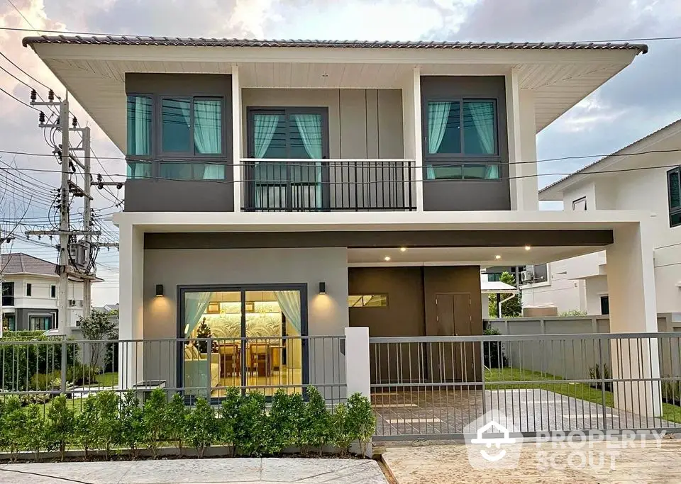 Modern two-story house with balcony and large windows in a serene neighborhood.