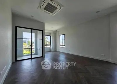 Spacious modern living room with large windows and elegant flooring