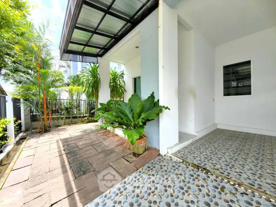 Charming entrance with lush greenery and stone pathway in modern home