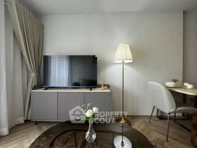 Modern living room with sleek TV stand, elegant floor lamp, and cozy dining area