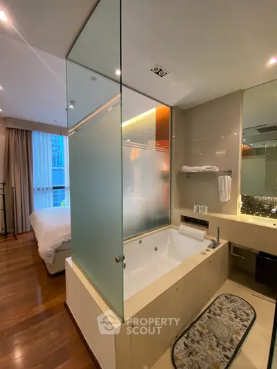 Luxurious bathroom with frosted glass partition and elegant bedroom view