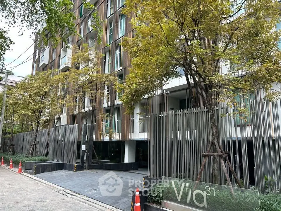 Modern urban apartment building with lush greenery and sleek architectural design.