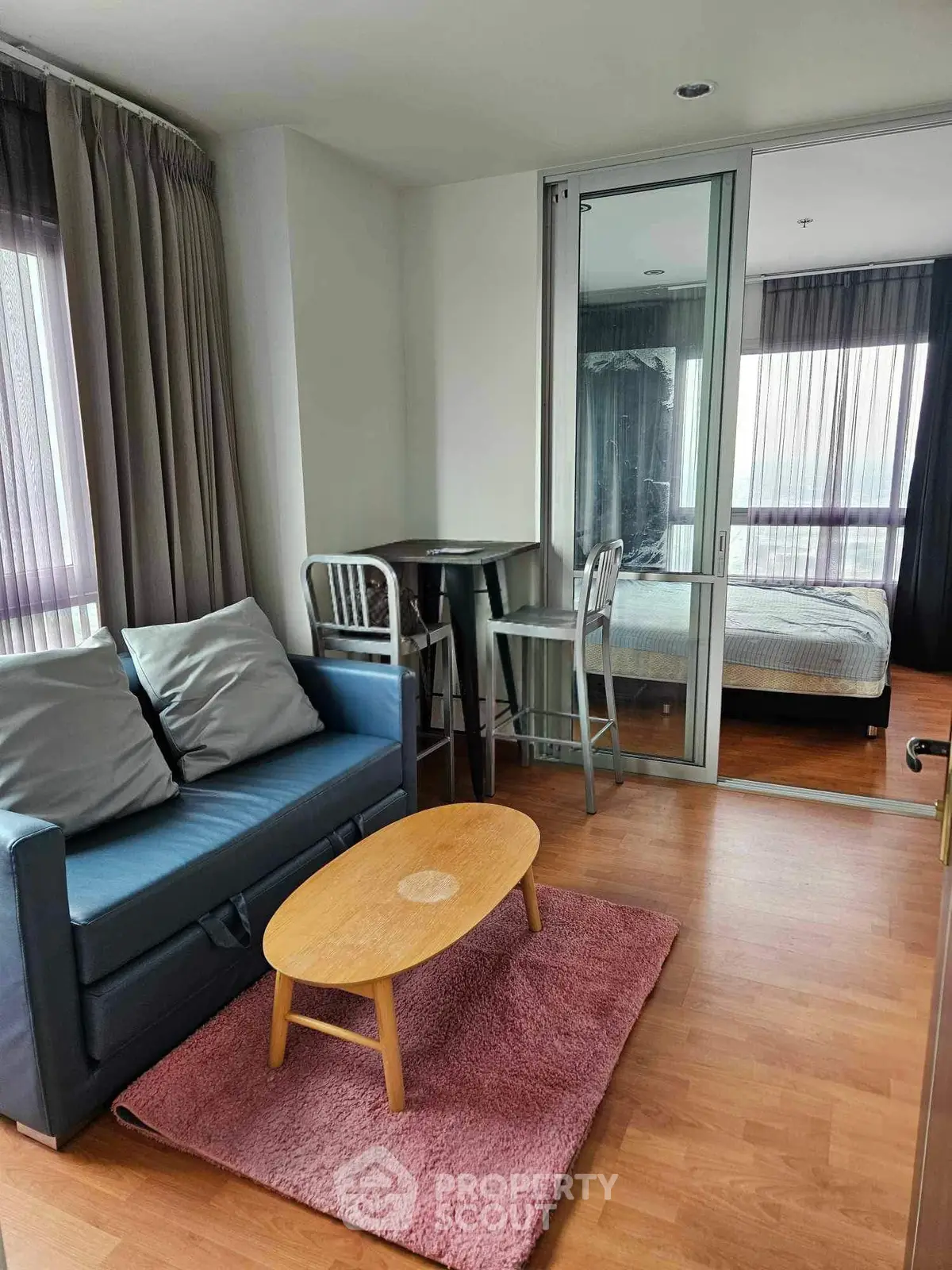 Cozy living room with modern decor and view into bedroom, featuring stylish furniture and natural light.