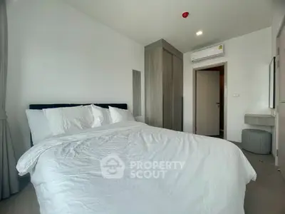 Modern bedroom with cozy bedding and sleek wardrobe in a stylish apartment.