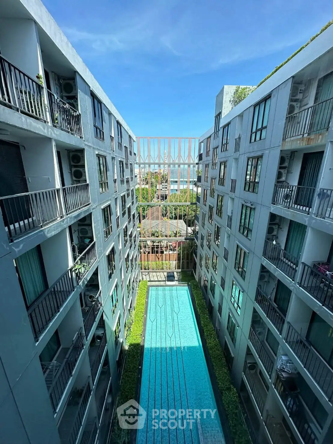 Modern apartment building with central swimming pool and balconies, offering a luxurious urban lifestyle.