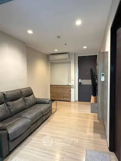 Modern living room with sleek leather sofa and wooden flooring