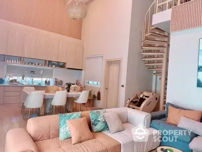 Spacious open-plan living room with modern kitchen, featuring stylish spiral staircase and cozy seating area.