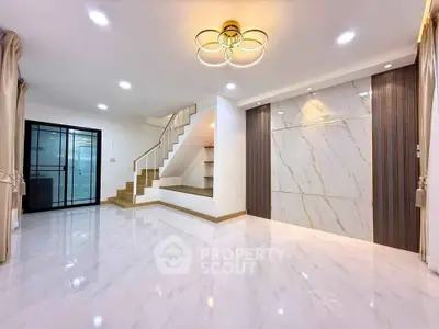 Spacious modern living room with elegant staircase and marble accent wall