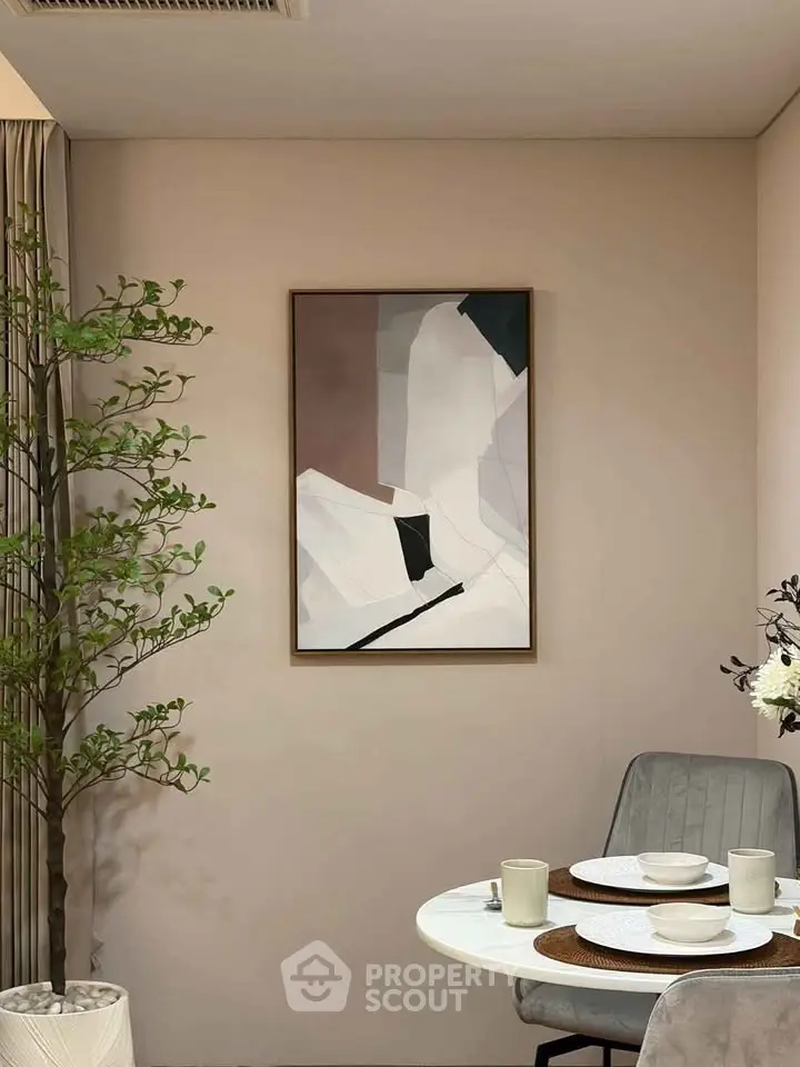 Stylish dining nook with modern art and elegant decor in a cozy apartment setting.