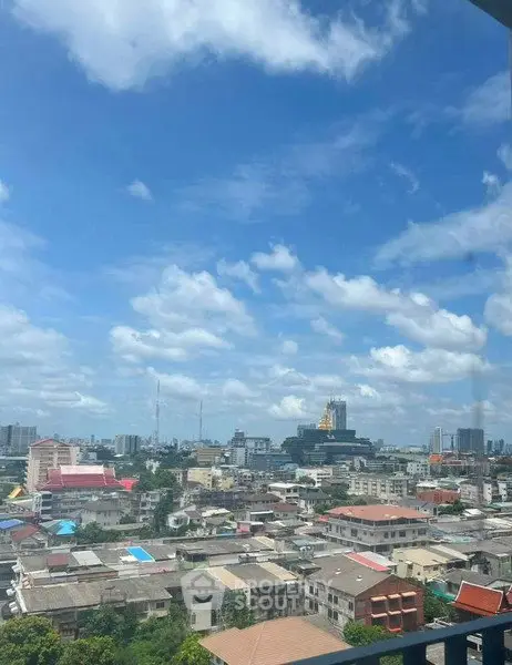 Stunning cityscape view from a high-rise balcony showcasing urban skyline under a clear blue sky.