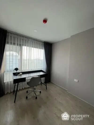 Modern study room with sleek desk and chair, large window with curtains, and minimalist decor.