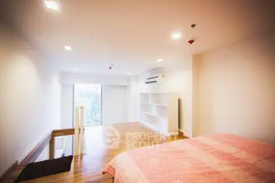 Spacious bedroom with wooden flooring and natural light in modern apartment