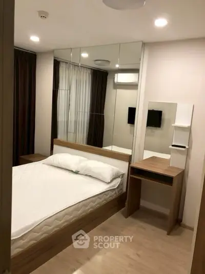 Modern bedroom with mirrored wall and minimalist furniture design