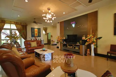 Luxurious living room with elegant decor, leather sofas, and modern lighting, perfect for relaxation and entertainment.